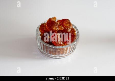 gomme arabique gros morceaux dans bol en verre vue du dessus sur fond blanc Banque D'Images