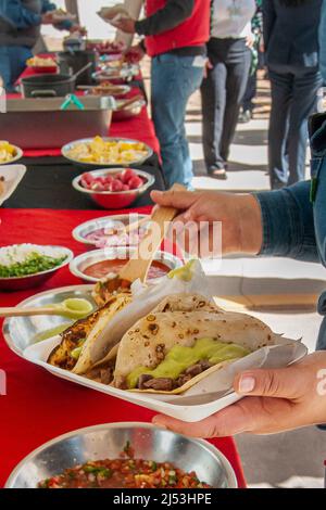 Photographie de la cuisine de rue, stand de tacos mexicains, carne asada tacos ou taquitos dans la rue, salsas épicées chaudes en arrière-plan. Tacos mexicains traditionnels Banque D'Images