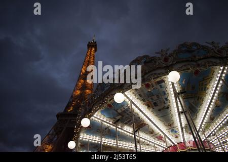 Paris, France, Europe : la Tour Eiffel vue de nuit avec le carrousel de la Tour Eiffel, un joyeux de style vintage 1900s Banque D'Images