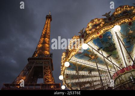 Paris, France, Europe : la Tour Eiffel vue de nuit avec le carrousel de la Tour Eiffel, un joyeux de style vintage 1900s Banque D'Images