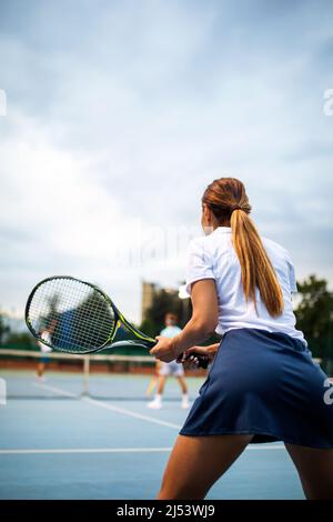 Portrait d'une jeune femme en forme heureuse jouant au tennis.Concept de mode de vie sain pour les gens