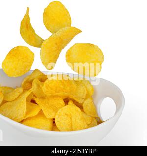 Chips de pommes de terre tombant dans un bol, isolé Banque D'Images