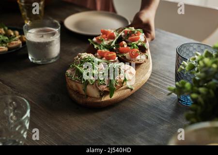 Gros plan de divers hors-d'œuvre servis sur une assiette en bois sur la table à manger pour le dîner des fêtes Banque D'Images