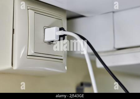 Deux fiches pour charger les smartphones sont insérées dans une prise de chargeur spéciale dans un wagon-compartiment d'un train de voyageurs Banque D'Images