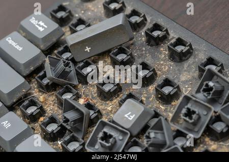 Gros plan d'un clavier d'ordinateur démontable très sale.Démontage d'un clavier d'ordinateur avec vos propres mains, nettoyage du clavier Banque D'Images