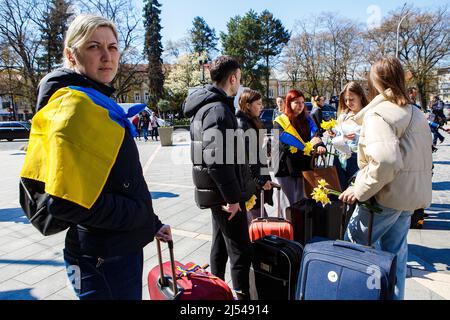 UZHHOROD, UKRAINE - le 19 AVRIL 2022 - Une femme enveloppée dans un drapeau ukrainien se tient dans une valise lors d'une procession pacifique depuis la place Petefi de Shandora Banque D'Images