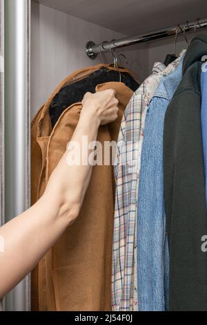 une femme porte un étui avec des vêtements dans une garde-robe. Photo de haute qualité Banque D'Images