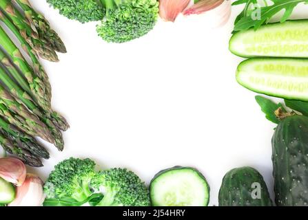 cadre de légumes verts brocoli, arugula, concombre, asperges et ail sur fond blanc Banque D'Images