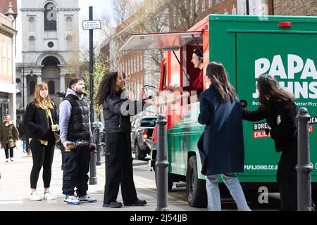 USAGE ÉDITORIAL SEULS les clients font la queue au camion alimentaire Papa Johns de Shoreditch, Londres, alors que la société lance son tout nouveau produit, un sandwich à pizza à pain plat plus léger, conçu comme une option de déjeuner qui peut être mangé d'une seule main, Lors d'un sondage mené par 2 000 adultes britanniques, on a trouvé que les sandwichs, les pizzas et les toasties sont les options préférées pour le déjeuner. Date de publication : le mercredi 20 avril 2022. Banque D'Images