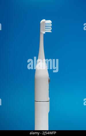 Brosse à dents électrique à ultrasons sur fond bleu. Banque D'Images