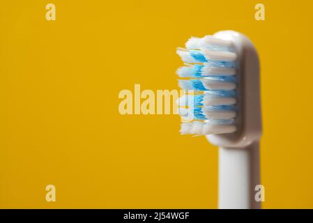 Brosse à dents électrique à ultrasons sur fond jaune. Banque D'Images