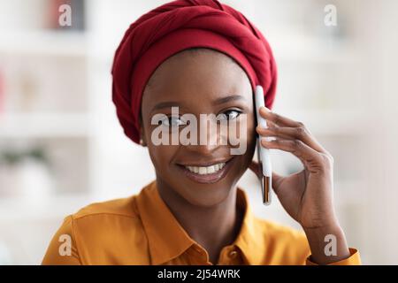 Portrait en gros plan d'une jolie femme noire parlant au téléphone Banque D'Images