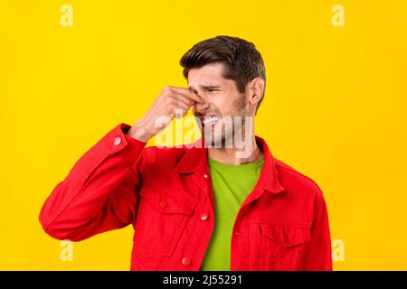 Portrait d'un type irritant attrayant touchant le bruit de fermeture mauvaise odeur isolée sur fond jaune vif Banque D'Images