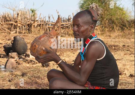 Hamar man drinking la bière de sorgho à partir d'une calebasse, vallée de la rivière Omo, dans le sud de l'Éthiopie Banque D'Images