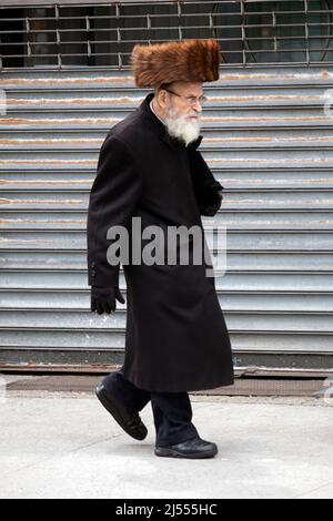 Un juif orthodoxe plus âgé marche sur lee Avenue à Williamsburg lors de la Pâque. Il porte un shtreimel, un chapeau traditionnel de sabbat et de vacances. À Brooklyn. Banque D'Images