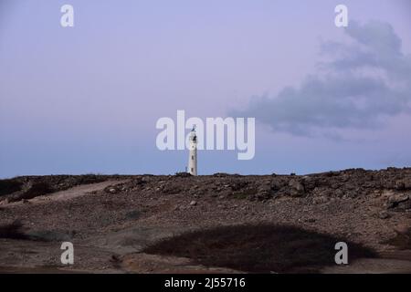 Un ciel rose au-dessus du phare de Californie à Noord Aruba. Banque D'Images