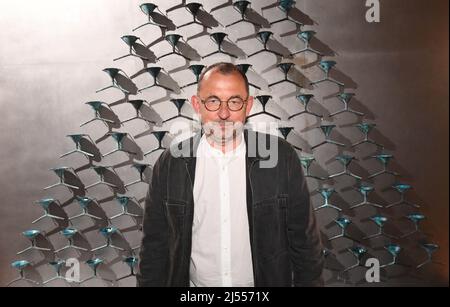 20 avril 2022, Italie, Veneig: L'artiste Pavlo Makov se tient devant son installation cinétique 'Fontaine d'épuisement. Acqua Alta' dans le pavillon ukrainien de l'Arsenale. Le dessinateur et sculpteur ukrainien a déclaré à dpa à Venise que « notre sort est décidé sur le front, pas ici ». Makov a décrit son travail, dans lequel l'eau continue de se diviser au-dessus de plusieurs entonnoirs, comme un « métaphor pour épuisement ». Photo: Felix Hörhager/dpa - ATTENTION: Seulement pour l'usage éditorial dans le cadre de la couverture de la Biennale d'art de Venise 59th et du Pavillon ukrainien et seulement avec le crédit complet donné ci-dessus Banque D'Images