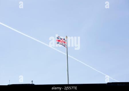 Un contrail est vu au-dessus d'un drapeau de l'Union volant sur le toit de Buckingham Palace dans le centre de Londres avant le jour de l'accession. Banque D'Images