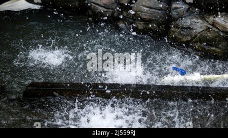 La roche artificielle est versée dans l'eau Banque D'Images