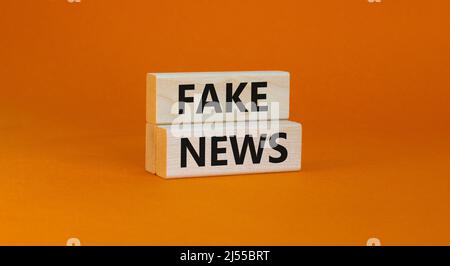 Symbole des fausses nouvelles. Blocs en bois avec des mots de concept fausses nouvelles sur beau fond orange. Médias d'affaires et fausses nouvelles concept. Copier l'espace. Banque D'Images