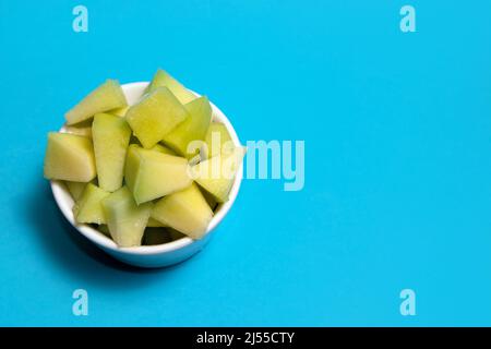 Melon dans un bol blanc sur fond bleu Banque D'Images