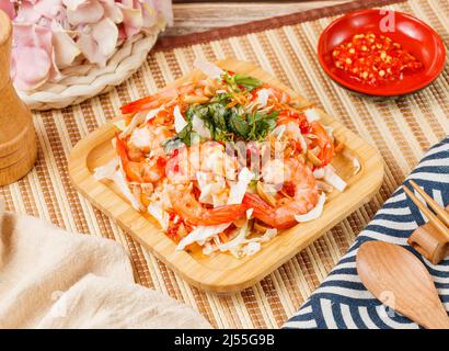 Salade de crevettes fraîches dans un bol avec une cuillère et des baguettes isolées sur le côté du tapis vue sur la table en bois de la nourriture taïwanaise Banque D'Images