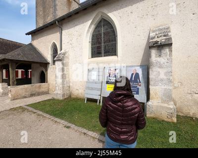 CHEVERNY, FRANCE - 20 AVRIL 2022 : Citzen devant une affiche officielle de campagne pour l'élection présidentielle française de 2022, Marine le Pen et Emmanuel Macron. Banque D'Images