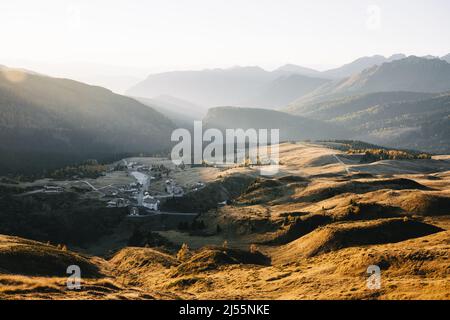 survol aérien des Dolomites italiennes au coucher du soleil. Collines orange illuminées par la lumière du coucher du soleil. San Martino di Castrozza, Dolomites, Trentin, Italie. Photographie de paysage Banque D'Images