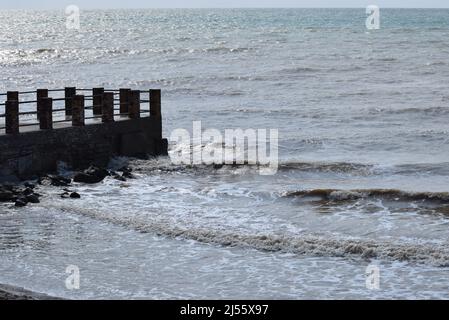 de grandes vagues de mer éclaboussant contre un quai. La jetée coupe les vagues de la mer au large de la côte pendant une journée ensoleillée. Banque D'Images