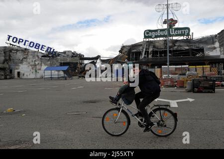 Bucha, Ukraine. 17th avril 2022. Un homme avec un enfant fait une balade en vélo devant un centre commercial détruit qui a été endommagé par les bombardements de l'armée russe dans la ville de Bucha. À Borodyanka, dans la région de Kiev, les sauveteurs ont sorti les corps de 41 morts de sous les décombres. Cela a été signalé par le centre de presse du Service d'État de l'Ukraine pour les situations d'urgence. La Russie a envahi l'Ukraine le 24 février 2022, déclenchant la plus grande attaque militaire en Europe depuis la Seconde Guerre mondiale (Credit image: © Sergei Chuzavkov/SOPA Images via ZUMA Press Wire) Banque D'Images