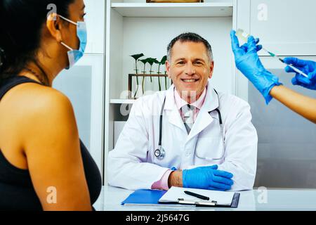 infirmière praticienne préparant l'injection à une patiente dans un hôpital médecin regardant l'industrie de la caméra de soins de santé Banque D'Images