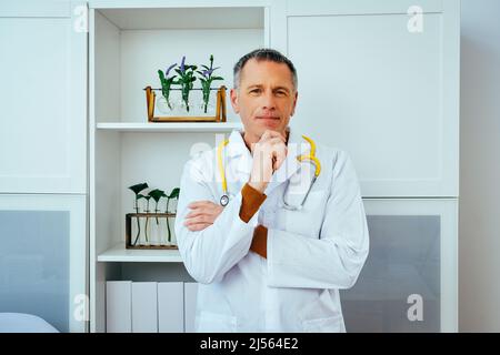 portrait en gros plan de pensif homme médecin médecin traitant en blouse de laboratoire avec l'industrie de la santé de stéthoscope Banque D'Images