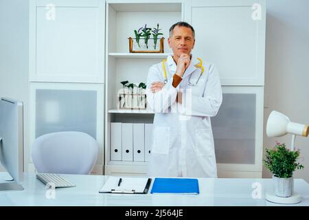 portrait pensif de médecin masculin en blouse de laboratoire avec l'industrie de la santé stéthoscope Banque D'Images