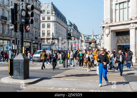 Piétons au croisement en diagonale à Oxford Circus, en regardant vers le nord sur Regent Street en direction de All Souls Church à Langham place, Londres, Royaume-Uni Banque D'Images