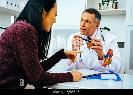 médecin praticien et patient discutant de l'anatomie cardiaque dans l'industrie de la santé hospitalière Banque D'Images