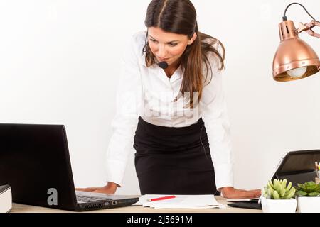Femme travaillant au bureau sur son bureau répondant à un appel téléphonique Banque D'Images