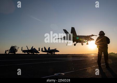 Aviation Boatswain's Mate (Equipment) 1st classe Aaron Wilson, d'Atlanta, affecté au service aérien de l'USS Gerald R. Ford (CVN 78), se dresse comme l'officier des engins d'arrêt en tant que F/A-18E Super Hornet, attaché au 'Golden Warriorss' de l'Escadron de chasseurs de grève (VFA) 87, se prépare à atterrir sur le pont de vol, 19 avril 2022. Ford est en cours dans l’océan Atlantique en menant des qualifications de transporteur et l’intégration du groupe de grève dans le cadre de la phase de base sur mesure du navire avant le déploiement opérationnel. (É.-U. Photo de la marine par le Spécialiste des communications de masse 2nd classe Zachary Melvin) Banque D'Images