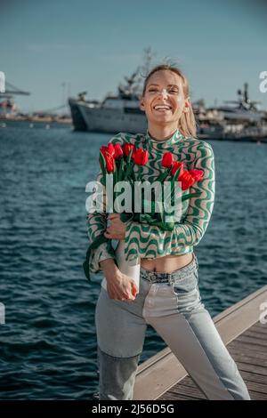 femme avec un bouquet de tulipes rouges dans le pot Banque D'Images