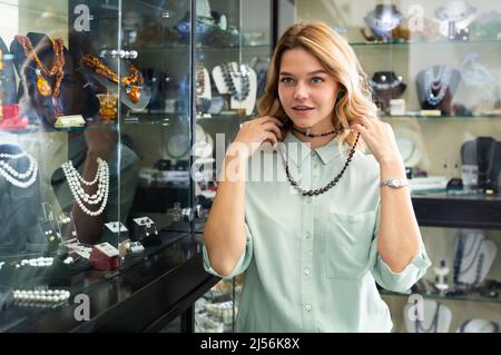 Femme choisissant des perles de pierre rouge profond Banque D'Images