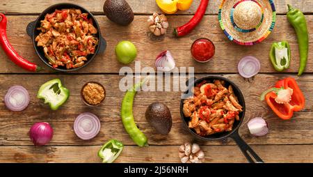 Composition avec de délicieux fajita, légumes, sauce et chapeau de sombrero sur fond de bois Banque D'Images