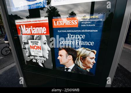 Paris, France, le 20 avril 2022, illustration du deuxième tour de l'élection présidentielle française entre le président actuel Emmanuel Macron et Marine le Pen ('RN', 'rassemblement National'), première page des hebdomadaires français 'Marianne' et 'l'Express' sur un kiosque à journaux (kiosque de presse) à Paris, France, le 20 avril 2022. Les électeurs français se dirigent vers les urnes pour voter le 24 avril 2022 pour le deuxième tour de l'élection présidentielle, pour élire leur nouveau président de la République. Banque D'Images