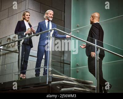 le directeur commercial caucasien accueille un client latino-américain dans un immeuble de bureaux moderne Banque D'Images