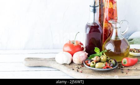 Un arrangement de vinaigre d'huile et de vin rouge sur une planche de bois rustique. Banque D'Images