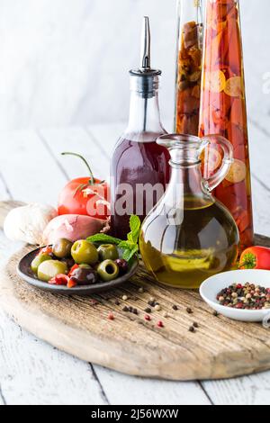 Vue verticale d'un assortiment d'huile et de vinaigre sur un panneau rustique en bois. Banque D'Images