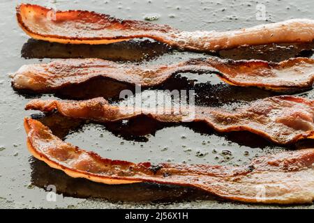 Friture de bacon sur une poêle à frire. Banque D'Images