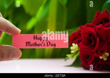 Bloc-notes avec texte « Happy Mother's day ». Roses et arrière-plan de la plante. Concept de fête des mères Banque D'Images