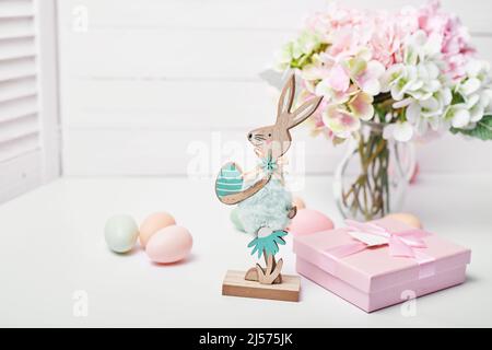 Carte de voeux « Happy easter eggs and bunny ». Bouquet de fleurs et boîte cadeau sur fond blanc Banque D'Images