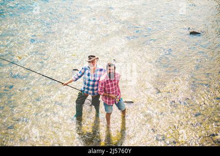 Pêcheurs hommes amis et truite trophée. Père et fils de pêche. Générations hommes pêche dans la rivière. Banque D'Images
