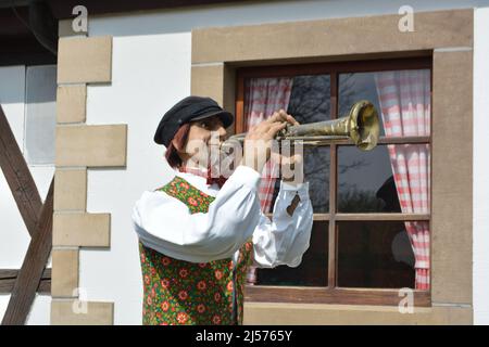 Poupée jouant la trompette devant une vieille maison Banque D'Images