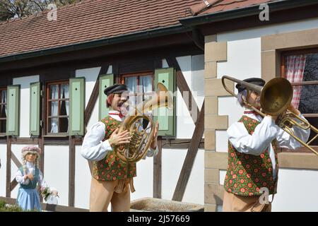 Poupée jouant la trompette devant une vieille maison Banque D'Images